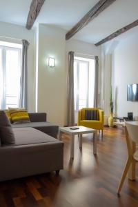 uma sala de estar com um sofá e uma mesa em Magnifiques Appartements au coeur du Vieux Nice em Nice
