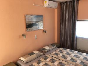 a bedroom with a bed with a checkeredkeredkered at Anissaras Beach Appartement in Hersonissos