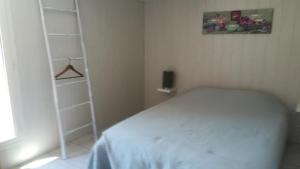 um quarto com uma cama branca e uma escada em Hotel de la Gare em Noyers-sur-Cher