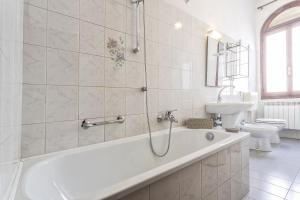 Baño blanco con bañera y lavamanos en Venice Dream House, en Venecia