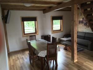 ein Wohnzimmer mit einem Tisch, Stühlen und einem Sofa in der Unterkunft Cottage Family in Hrabušice