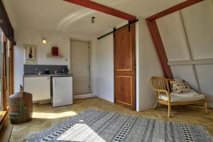 um quarto com uma cama e uma cadeira e uma cozinha em Rooftop studio near Amsterdam Castle (Muiden) em Muiden