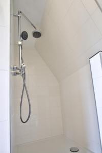 een douche met een douchekop in een badkamer bij Rooftop studio near Amsterdam Castle (Muiden) in Muiden