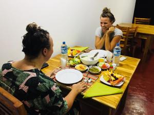 zwei Frauen sitzen an einem Tisch und essen Essen in der Unterkunft Victory Villa Sigiriya in Sigiriya