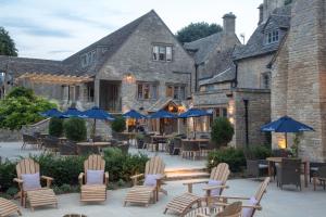a patio area with chairs, tables and umbrellas at The Frogmill Hotel in Cheltenham