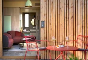 a living room with a table and chairs and a room with at Maison d'hôtes Le Pré Gourmand du Village- Adults only in Eyragues