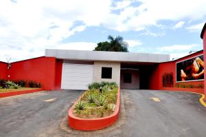 a red building with a white garage at Motel Passport in Guaratinguetá