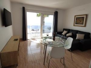 ein Wohnzimmer mit einem Glastisch und einem Sofa in der Unterkunft Apartamentos Capellania in Puerto del Carmen