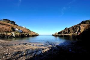 a large body of water with a rocky shore at Port Gaverne Hotel in Port Isaac