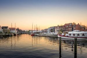 een rivier met boten aangemeerd in een stad bij Ferienwohnung Urlaub in Greifswald