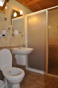 y baño con aseo, lavabo y ducha. en Ozge Bungalow Hotel, en Cıralı