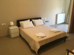 sypialnia z dużym łóżkiem z dwoma ręcznikami w obiekcie Stellar Beachhouse w mieście Gerani
