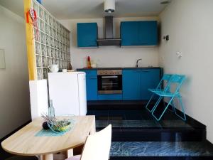 a kitchen with blue cabinets and a wooden table at Apartment Naita in Sinj