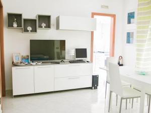 una cucina bianca con TV e scrivania di Lumarosa Home a Polignano a Mare