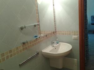La salle de bains est pourvue d'un lavabo et d'un miroir. dans l'établissement villa Mirtilla, à Villasimius