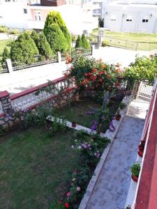 un jardín con flores y un banco en un edificio en Alvanita Apartments, en Ulcinj
