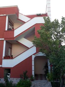 un edificio rojo y blanco con entrada en Alvanita Apartments, en Ulcinj