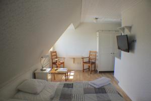 a small room with a bed and a table and chairs at Klitgaarden Henne Strand in Henne Strand