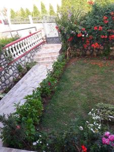 un jardín con un banco y un ramo de flores en Alvanita Apartments, en Ulcinj