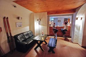 ein Wohnzimmer mit einem schwarzen Ledersofa und einem Tisch in der Unterkunft Pod Orlicą in Zieleniec