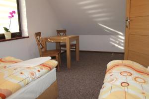 a room with two beds and a table and chairs at Domki w porcie Zielony Gaj in Mikołajki