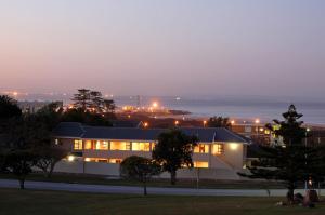 a building at night with the ocean in the background at Lalapanzi Guest Lodge in Port Elizabeth
