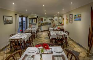 a restaurant with tables and chairs in a room at Lalapanzi Guest Lodge in Port Elizabeth