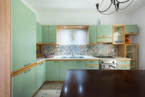 a kitchen with mint green cabinets and a sink at Kriopigi Pines by the Sea by Luxlikehome in Kriopigi