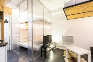 パリにあるPretty 25 m2 in a lively districtのガラスケースのベッド1台が備わる部屋