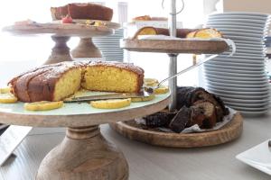 a cake on a three tiered stand with different types of cakes at Yes Hotel Touring & SPA in Rimini