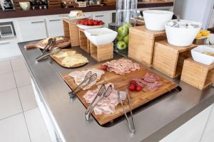 a kitchen counter with meat and other foods on a cutting board at Yes Hotel Touring & SPA in Rimini
