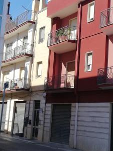 a red building with balconies and a garage at DAMALU' in Conversano