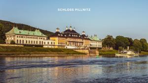 ein großes Gebäude an der Seite eines Flusses in der Unterkunft Traumhafte Ferienwohnung im Luisenhof in Dresden