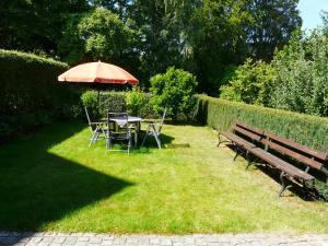 einem Picknicktisch mit einem Sonnenschirm und einem Tisch mit Stühlen in der Unterkunft Ferienhaus Uda in Schwarzenberg