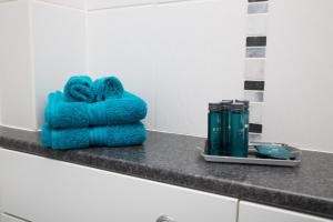 a pile of blue towels sitting on a counter in a bathroom at Polly Cottage in Teignmouth +22 photos