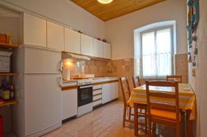 kuchnia ze stołem i białą lodówką w obiekcie Carmelo House w Rovinj