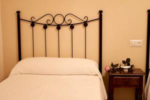 a bed with a metal headboard and a wooden table at Casas rurales amable- yeste in Cortijo Prados