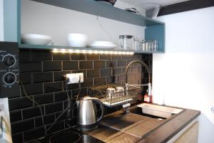 a kitchen with a sink and a counter with dishes at Luminous 20m² district of BATIGNOLLES in Paris
