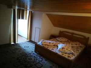 a bedroom with a bed with a wooden headboard at Pensiunea Remus in Novaci