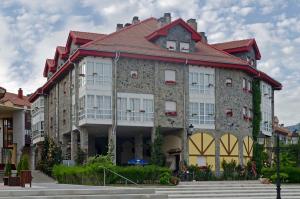 um grande edifício de pedra com um telhado vermelho em Hotel Presa em Riaño