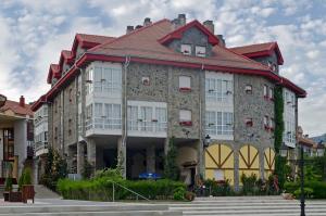a large stone building with a red roof at Hotel Presa in Ria&ntilde;o