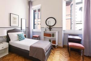 a bedroom with a bed and a table and a mirror at ROMAC Villa Medici 3-Bedroom Holiday Apartment near Spanish Steps in Rome
