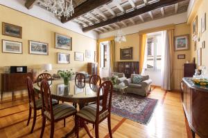 a living room with a table and chairs and a couch at ROMAC Villa Medici 3-Bedroom Holiday Apartment near Spanish Steps in Rome