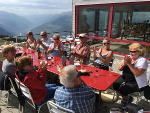 a group of people sitting at tables on a patio at Restaurant Fleschboden in Rosswald