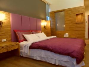 六龜區的住宿－妞妞與夢卡民宿 ，一间卧室配有一张带粉红色床头板的大床