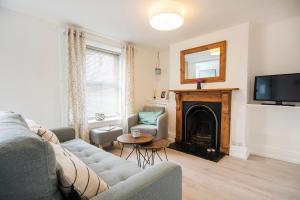 a living room with a couch and a fireplace at Cornish Cottage - Truro City Centre in Truro