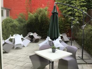 eine Gruppe von Tischen und Stühlen mit einem Schirm in der Unterkunft Bon-Apart in Görlitz