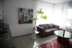 ein Wohnzimmer mit einem Sofa und einem Tisch in der Unterkunft Apartmentvermietung Dortmund-Kirchhörde in Dortmund