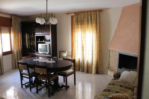a dining room with a table and a fireplace at Casa Miguel in La Portellada