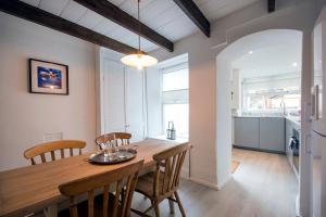 a kitchen and dining room with a wooden table and chairs at Cornish Cottage - Truro City Centre in Truro